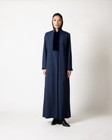 A model stands facing forward wearing a long navy blue hooded abaya with a contrasting dark navy velvet chest panel and black pointed shoes, photographed against a neutral light gray studio background.عبايات قطر | Abaya Qatar
عبايات الدوحة | Abayas Doha
عباية قطر | Abaya Doha
عبايات اونلاين قطر | Abayas Online Qatar
عبايات أونلاين قطر | Online Abayas Qatar
شراء عبايات قطر | Buy Abaya Qatar
شراء عبايات اونلاين | Buy Abayas Online
متجر عبايات قطر | Abaya Store Qatar
محل عبايات قطر | Abaya Shop Qatar
بوتيك عبا