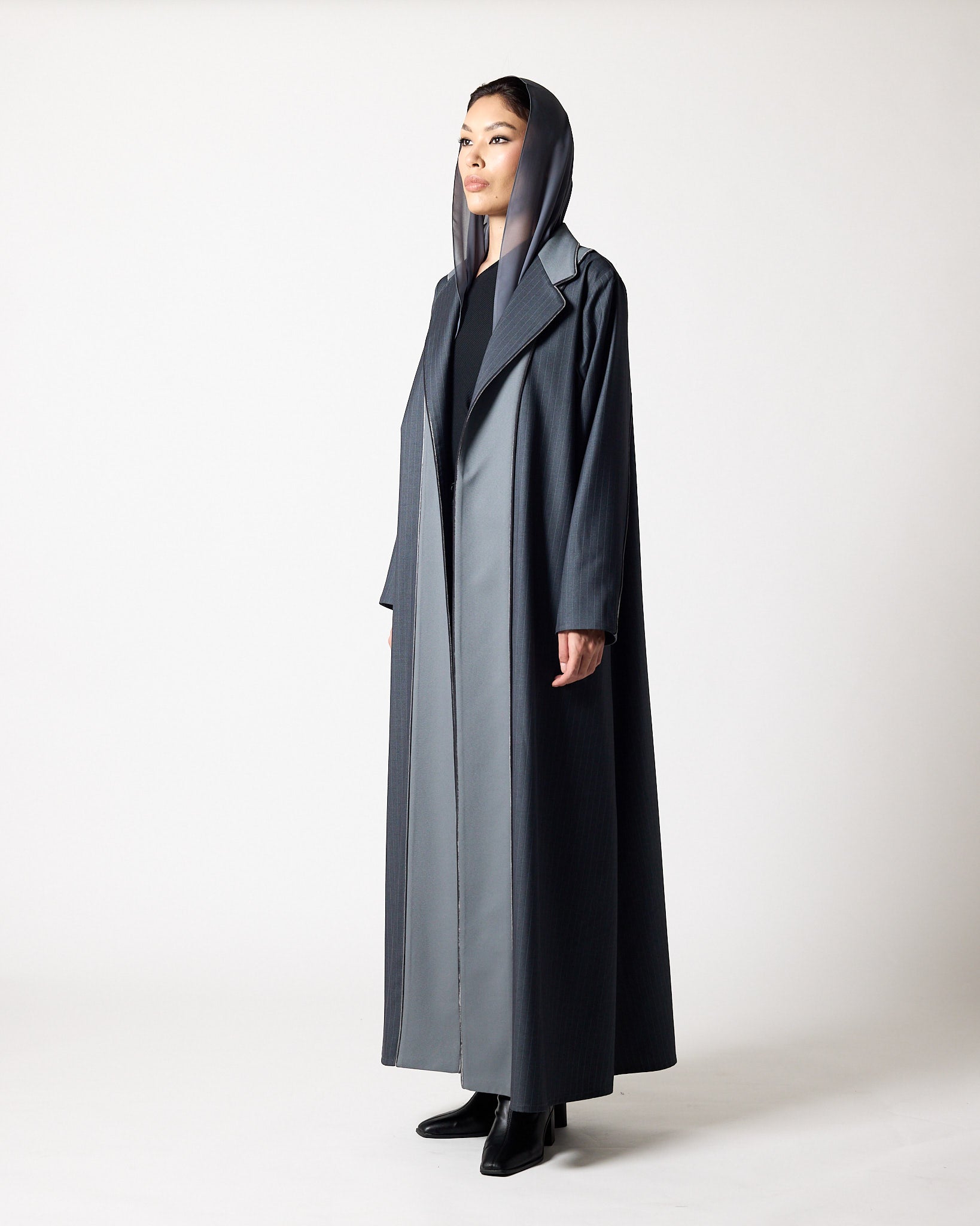 A model wearing a long, dark gray hooded coat over a matching gray dress and black shoes, standing against a plain light gray studio background.عبايات قطر | Abaya Qatar
عبايات الدوحة | Abayas Doha
عباية قطر | Abaya Doha
عبايات اونلاين قطر | Abayas Online Qatar
عبايات أونلاين قطر | Online Abayas Qatar
شراء عبايات قطر | Buy Abaya Qatar
شراء عبايات اونلاين | Buy Abayas Online
متجر عبايات قطر | Abaya Store Qatar
محل عبايات قطر | Abaya Shop Qatar
بوتيك عبايات قطر | Abaya Boutique Qatar
عبايات نسائية قطر | Ladies