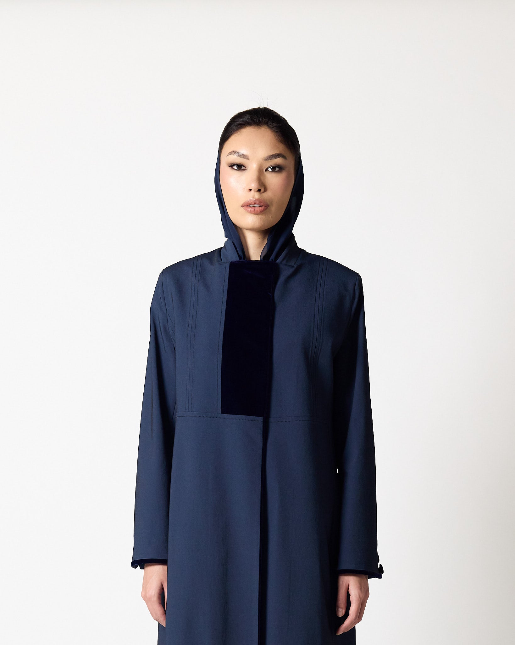 A model wearing a dark navy blue hooded abaya with a contrasting black velvet panel at the chest, photographed against a plain white studio background.عبايات قطر | Abaya Qatar
عبايات الدوحة | Abayas Doha
عباية قطر | Abaya Doha
عبايات اونلاين قطر | Abayas Online Qatar
عبايات أونلاين قطر | Online Abayas Qatar
شراء عبايات قطر | Buy Abaya Qatar
شراء عبايات اونلاين | Buy Abayas Online
متجر عبايات قطر | Abaya Store Qatar
محل عبايات قطر | Abaya Shop Qatar
بوتيك عبايات قطر | Abaya Boutique Qatar
عبايات نسائية قطر |