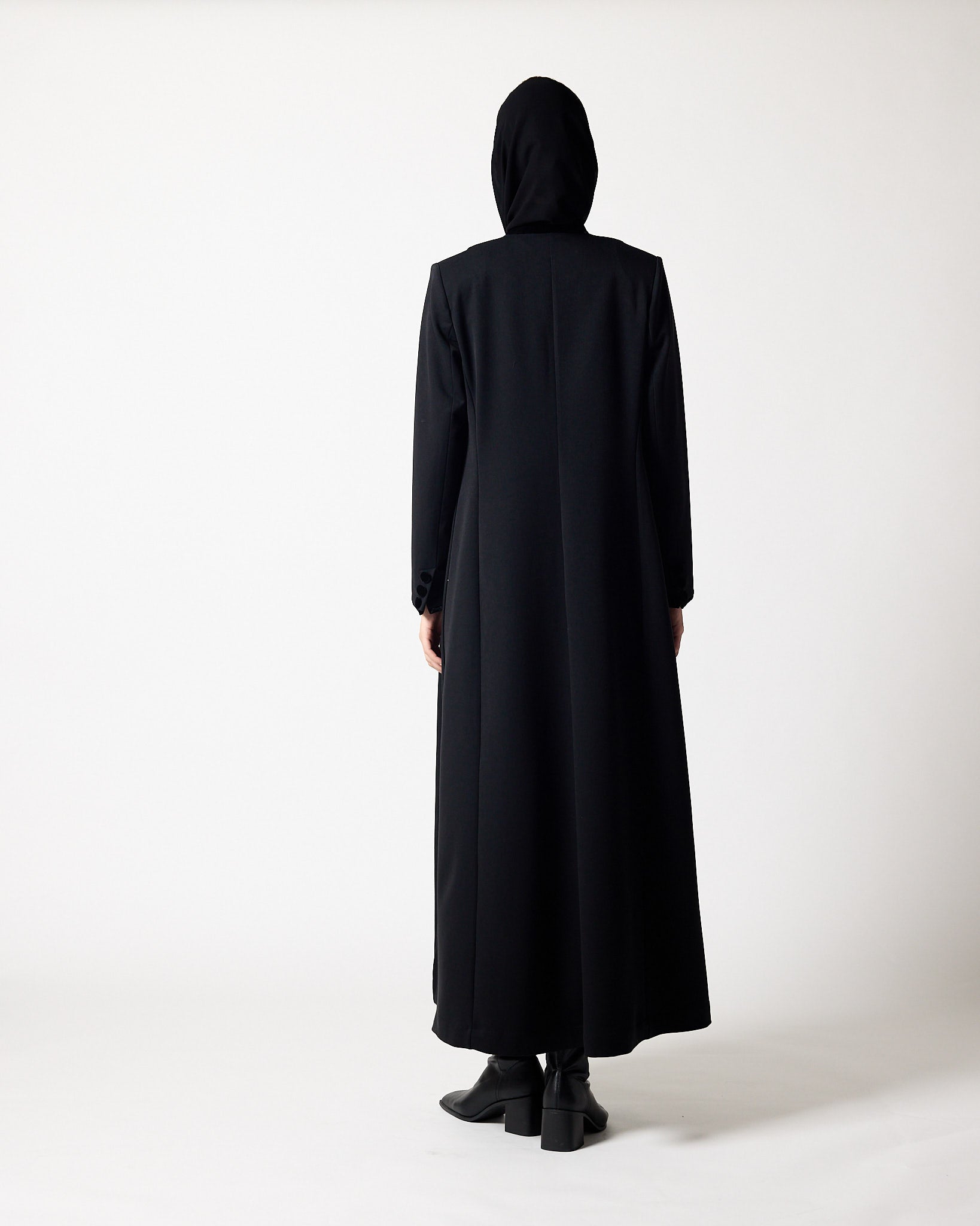 A person viewed from the back wearing a long black hooded abaya or long robe with wide sleeves, paired with black shoes, against a plain light gray studio background.عبايات قطر | Abaya Qatar
عبايات الدوحة | Abayas Doha
عباية قطر | Abaya Doha
عبايات اونلاين قطر | Abayas Online Qatar
عبايات أونلاين قطر | Online Abayas Qatar
شراء عبايات قطر | Buy Abaya Qatar
شراء عبايات اونلاين | Buy Abayas Online
متجر عبايات قطر | Abaya Store Qatar
محل عبايات قطر | Abaya Shop Qatar
بوتيك عبايات قطر | Abaya Boutique Qatar
عباي
